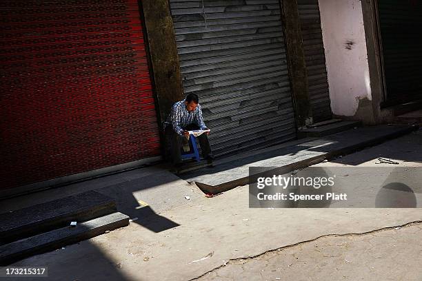 Man reads the paper in a closed market on the first day of Ramadan, the sacred holy month for Muslims where many will fast from sun-up to sun-down on...