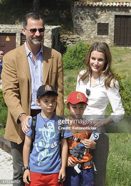 Prince Felipe of Spain and Princess Letizia of Spain pose with two children visitors during their visit to Sierra de Guadarrama National Park on July...