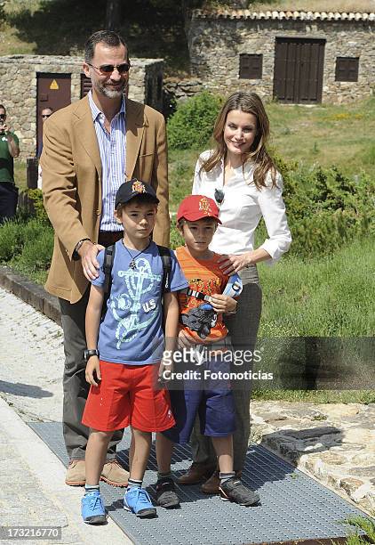 Prince Felipe of Spain and Princess Letizia of Spain pose with two children visitors during their visit to Sierra de Guadarrama National Park on July...