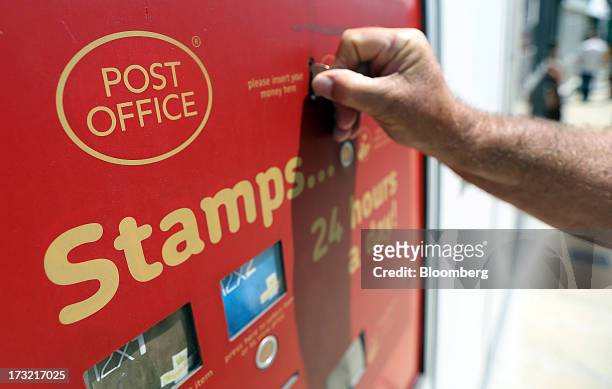 Customer uses an automated machine to buy stamps outside a Royal Mail Group Ltd. Post office in Hornchurch, U.K., on Wednesday, July 10, 2013. The...
