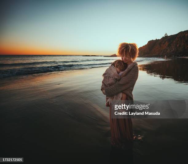 mother holding toddler - beach evening - boy skirt stock pictures, royalty-free photos & images