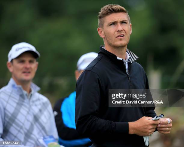 Lloyd Saltman of Scotland is watched by the US Open Champion Justin Rose of England during a practice round as a preview for the 2013 Open...