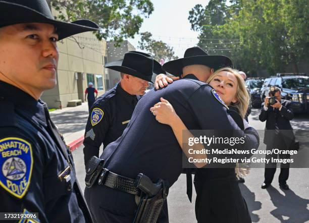 Cypress, CA Hailey Swanson, wife of Manhattan Beach Police Officer Chad Swanson, hugs other officers after his funeral at SeaCoast Grace Church in...