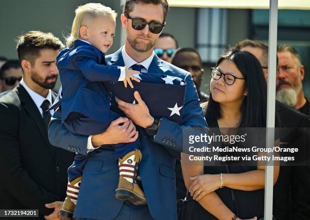 Cypress, CA Corey Swanson holds one of his nephews during his brother's funeral at SeaCoast Grace Church in Cypress, CA, on Wednesday, Oct. 18, 2023....