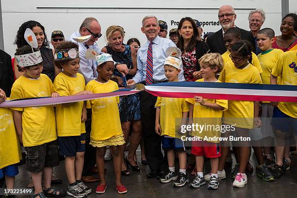 Susan Marenoff-Zausner, president of the Intrepid Sea, Air and Space Museum, cuts the ribbon announcing the re-opening of the Space Shuttle...