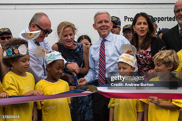 Susan Marenoff-Zausner, president of the Intrepid Sea, Air and Space Museum, cuts the ribbon announcing the re-opening of the Space Shuttle...