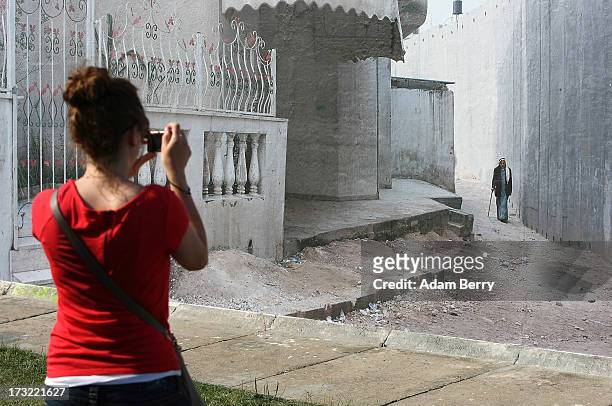 Visitor takes a photo of a separation wall in Nazlat Issa, in the West Bank, Occupied Palestinian Territories, as it hangs as part of the 'Wall on...