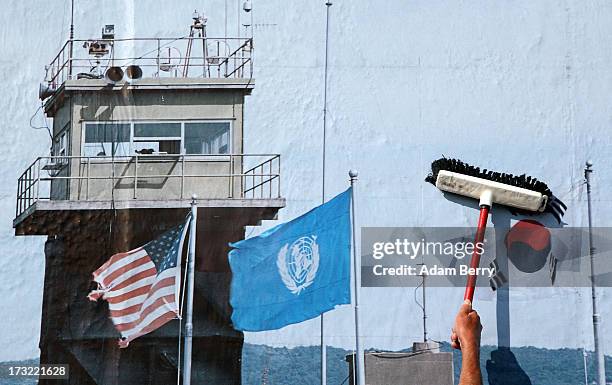 Worker hangs a photo of the North and South Korean border's Demilitarized Zone as part of the 'Wall on Wall' exhibition at the East Side Gallery...