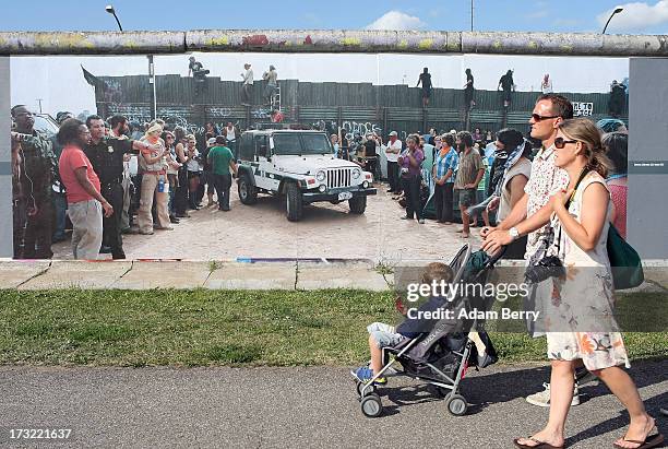 Family of tourists passes a photo of the United States-Mexico border in Calexico, California, hanging as part of the 'Wall on Wall' exhibition at the...