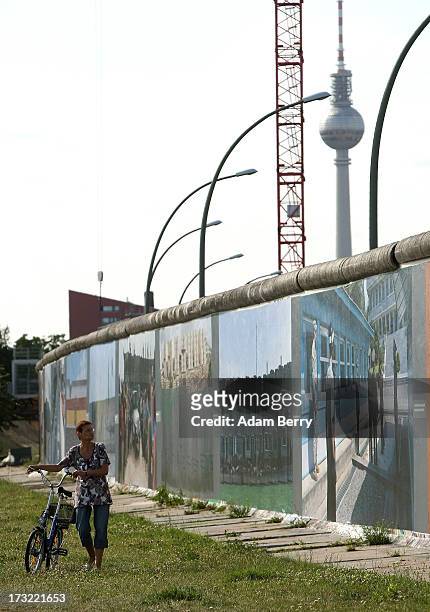 Visitor looks at the 'Wall on Wall' exhibition at the East Side Gallery section of the former Berlin Wall on July 10, 2013 in Berlin, Germany. A...