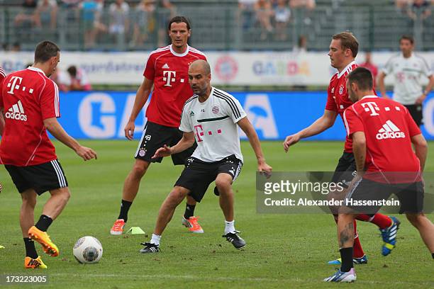 Head coach Josep Guardiola of FC Bayern Muenchen battles for the ball with his players Franck Ribery , Daniel van Buyten , Manuel Neuer and Diego...