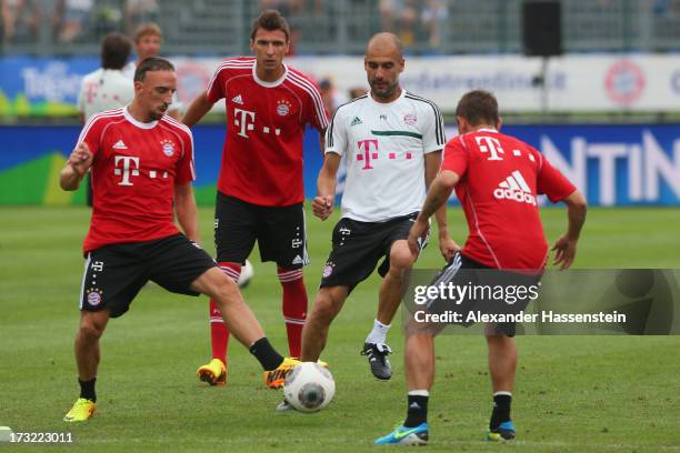 Head coach Josep Guardiola of FC Bayern Muenchen battles for the ball with his players Franck Ribery , Mario Mandzukic , and Rafinha during a...