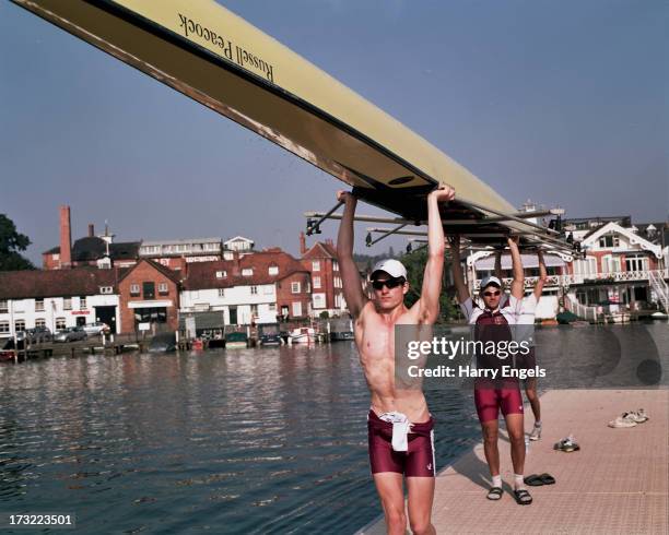 Crew carries its boat back to the boat tent after completing a warm up row during the Henley Royal Regatta on July 7, 2013 in Henley-on-Thames,...