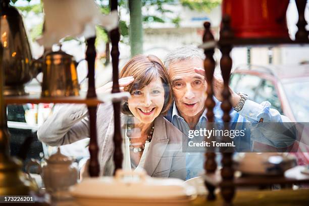 couple peeking through shopping window - man in antique shop stock pictures, royalty-free photos & images