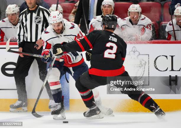 Tom Wilson of the Washington Capitals controls the puck against Artem Zub of the Ottawa Senators at Canadian Tire Centre on October 18, 2023 in...