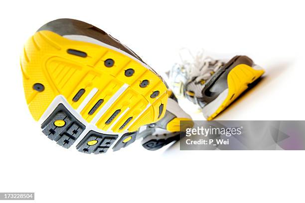 a pair of gray running shoes with yellow soles, stepping - sole of shoe stock pictures, royalty-free photos & images