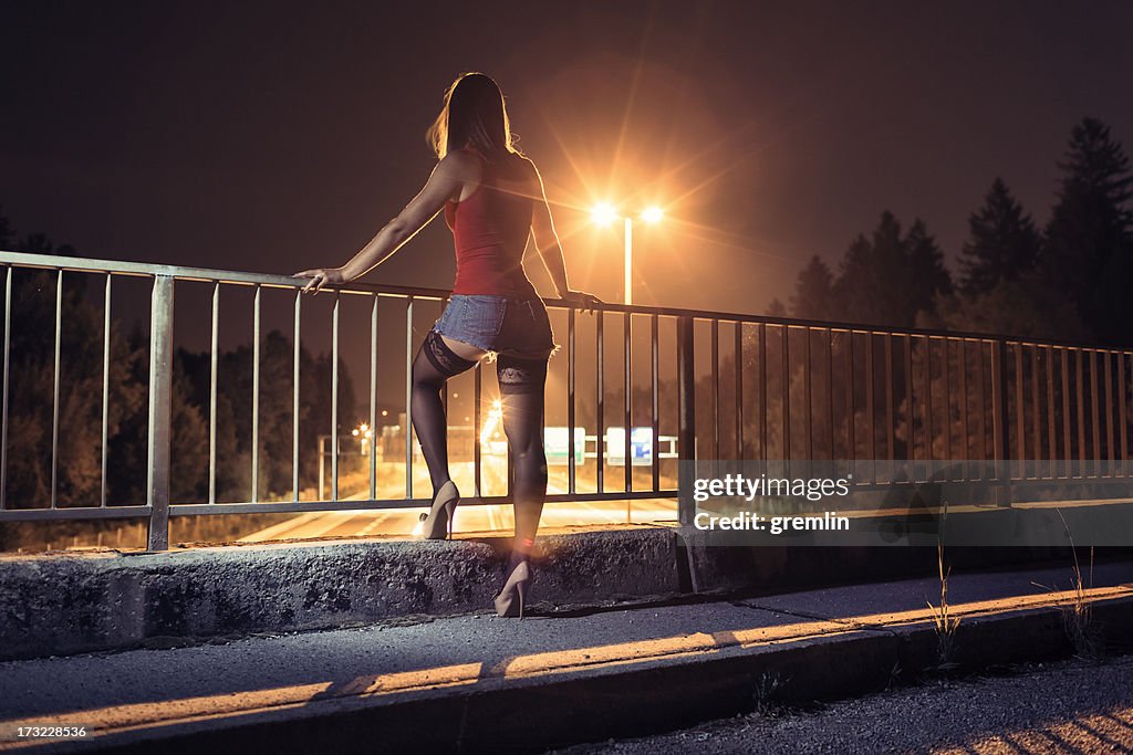 Desperate young woman standing on the bridge