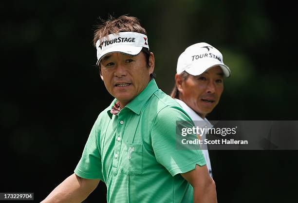 Joe Ozaki and Kohki Idoki of Japan watch a shot during a practice round prior to the start of the 2013 U.S. Senior Open Championship at Omaha Country...