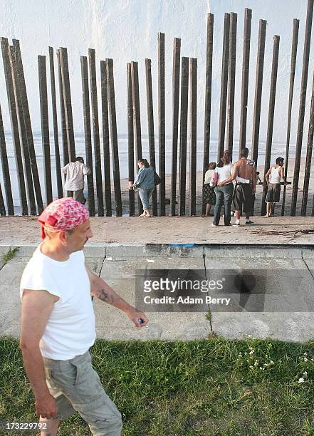 Visitors passes in front of a photo of the United States-Mexico border in Tijuana, Mexico, as it hangs as part of the 'Wall on Wall' exhibition at...