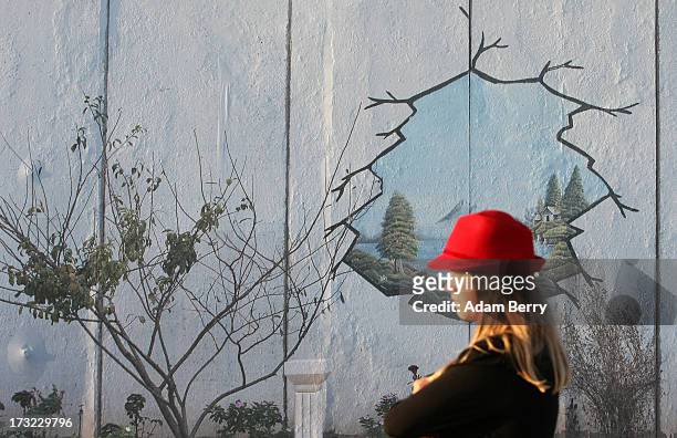 Visitor stands in front of a photo of a separation wall at Nazlat Issa in the West Bank, Occupied Palestinian Territories, in the 'Wall on Wall'...