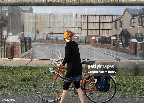 Visitor passes a photo of the Belfast Peace lines in Northern Ireland in the 'Wall on Wall' exhibition at the East Side Gallery section of the former...