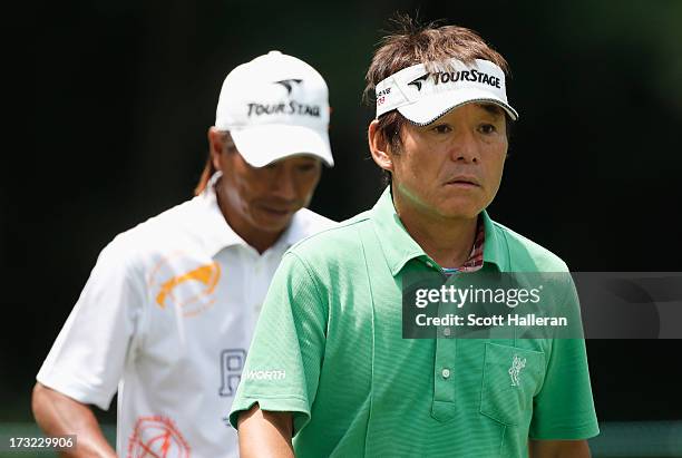 Joe Ozaki and Kohki Idoki of Japan walk off a tee box during a practice round prior to the start of the 2013 U.S. Senior Open Championship at Omaha...