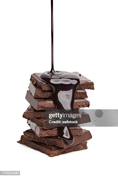 liquid chocolate being poured on a stack of solid chocolate  - liquid chocolate stock pictures, royalty-free photos & images