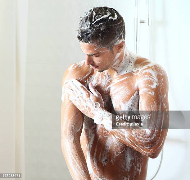 young man taking a shower. - soap sud stock pictures, royalty-free photos & images
