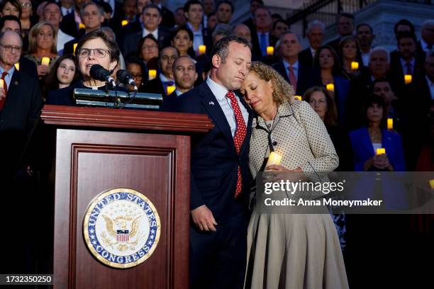 Reps. Josh Gottheimer and Debbie Wasserman Schultz embrace as Margaret Grun Kibben, chaplain of the House of Representatives, leads a prayer at a...