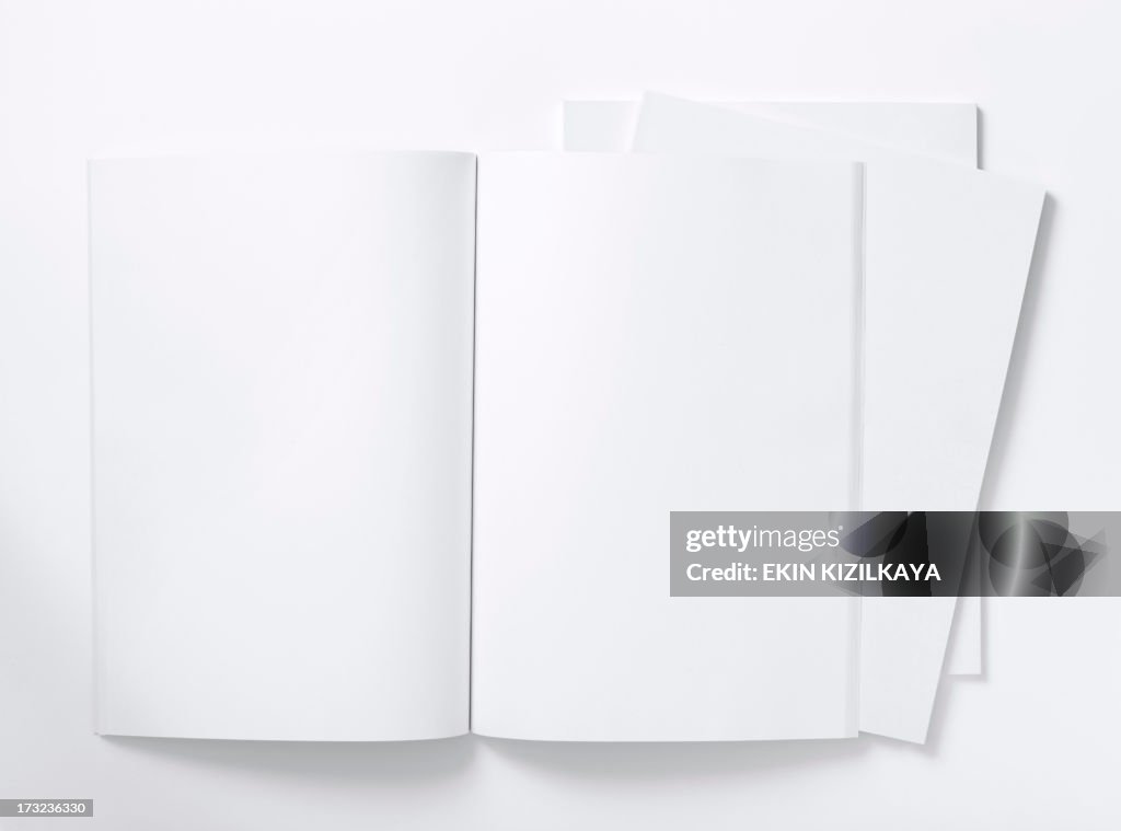 Blank white magazine lying open on a white table