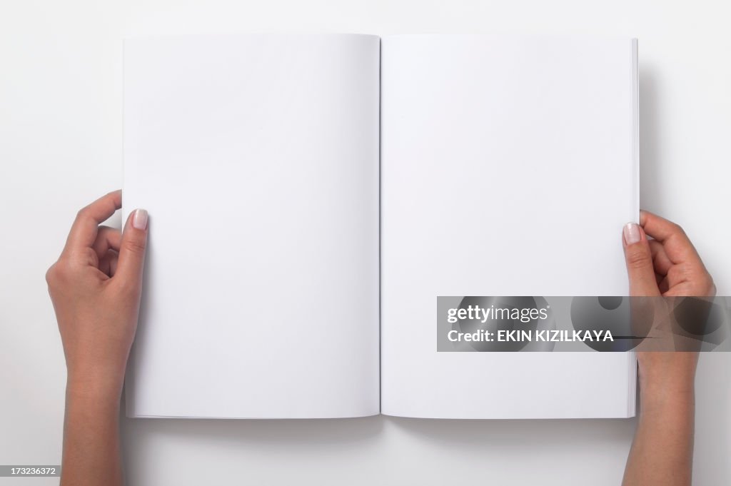 Two Female Hands Holding Open A Blank Magazine