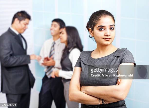 attractive indian businesswoman with colleagues in the background - beautiful people stock pictures, royalty-free photos & images