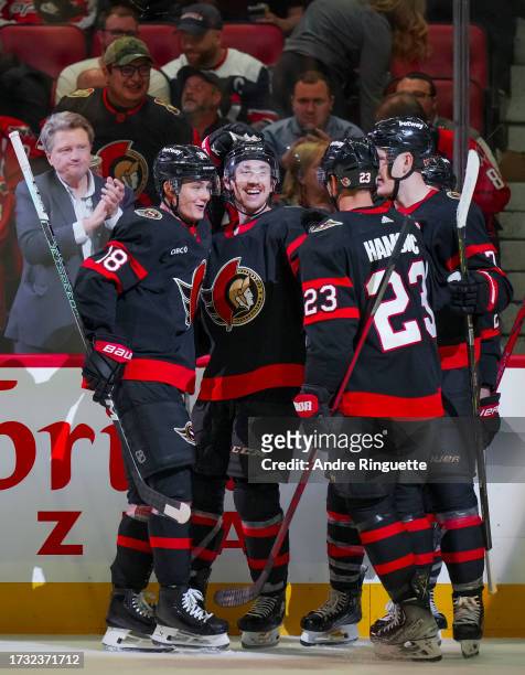 Jake Sanderson of the Ottawa Senators celebrates his third period goal against the Washington Capitals with teammates Tim Stützle, Travis Hamonic and...