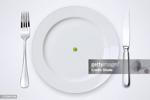 one green pea on plate. table setting with clipping path. - tafelmes stockfoto's en -beelden
