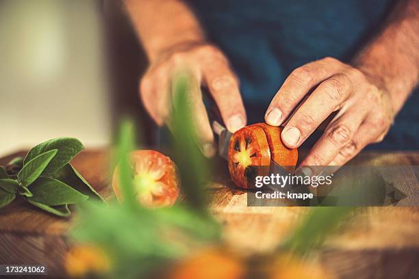 mann schneiden von tomaten in rustikalen küche - colorful vegetables summer stock-fotos und bilder