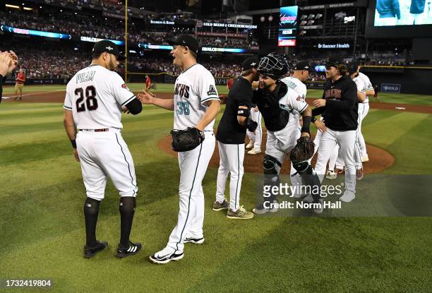 Paul Sewald of the Arizona Diamondbacks and Tommy Pham celebrate a win against the Los Angeles Dodgers during Game Three of the Division Series at...