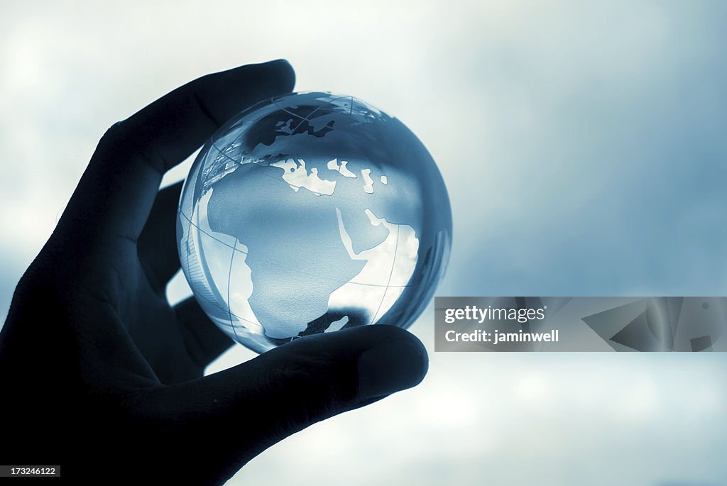 Hand holding crystal globe