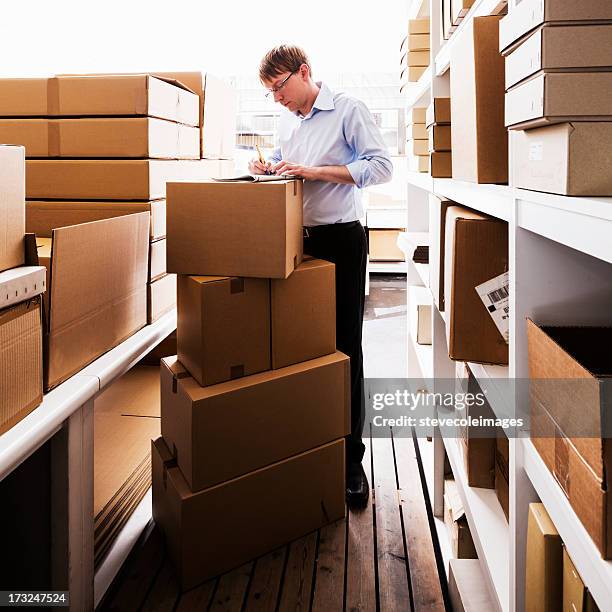 man handling paperwork in a warehouse - material handling stock pictures, royalty-free photos & images