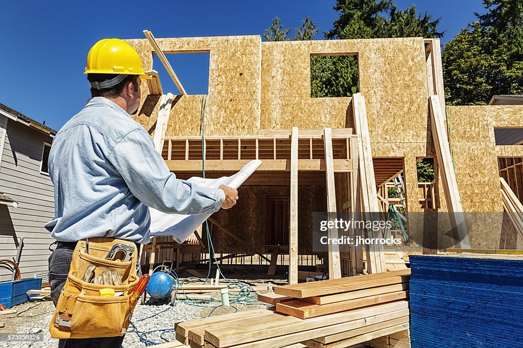 Bauarbeiter auf Haus Pläne