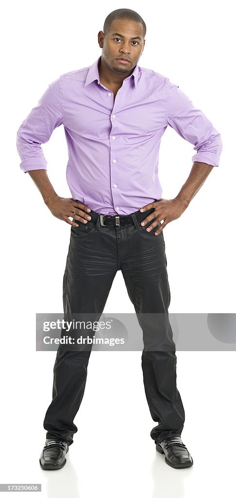 Confiante jovem de pé com as mãos nos quadris