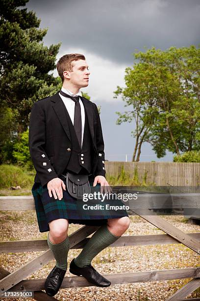 scotsman sitting on a gate outdoors - kilt stock pictures, royalty-free photos & images