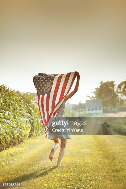 patriotic girl flying american flag, usa fourth of july banner - vlag plaatsen stockfoto's en -beelden