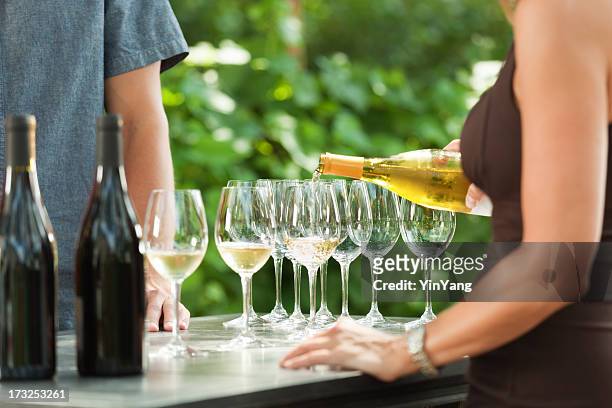 bartender pouring white wine from bottle for outdoor winery tasting - wijn proeven stockfoto's en -beelden