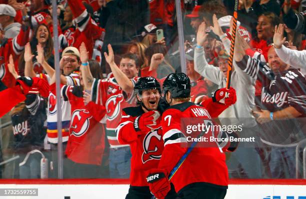 Dougie Hamilton of the New Jersey Devils celebrates his goal at 15:37 against the Detroit Red Wings and is joined by Tyler Toffoli at the Prudential...