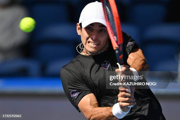 Chile's Christian Garin hits a return to Australia's Alexei Popyrin during their men's singles match on day four of the ATP Japan Open tennis...