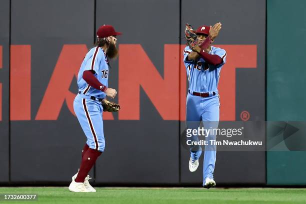 Brandon Marsh and Johan Rojas of the Philadelphia Phillies react after Rojas made a catch in the seventh inning against the Atlanta Braves during...