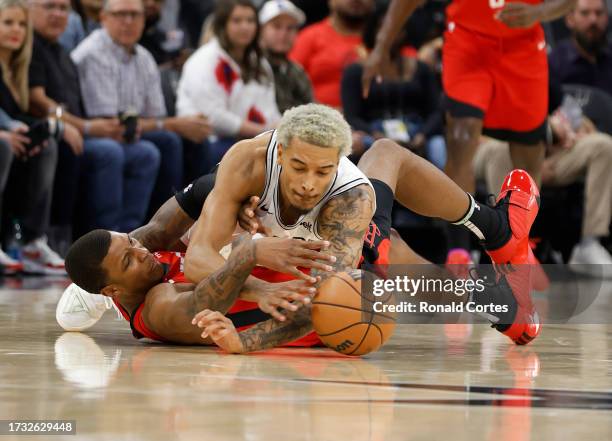 Jeremy Sochan of the San Antonio Spurs dives for a loose ball over Jabari Smith of the Houston Rockets in the first half of a pre-season NBA game at...