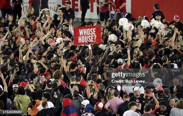 Houston Cougar fans celebrate on the field after the Cougars scored on a 49 yard hail mary pass to beat the West Virginia Mountaineers 41-39 at TDECU...