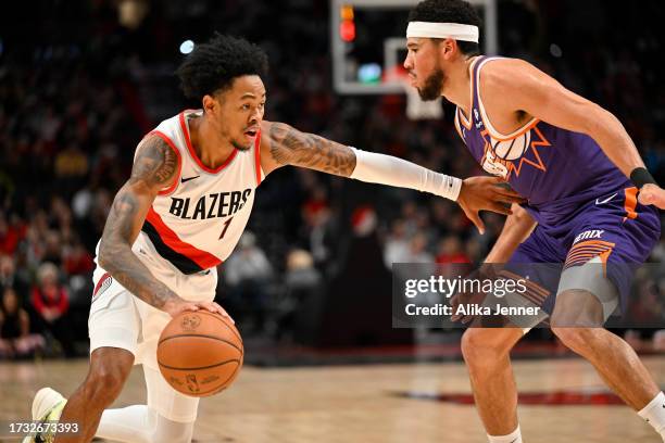 Anfernee Simons of the Portland Trail Blazers drives against Devin Booker of the Phoenix Suns during the first quarter of the preseason game at Moda...