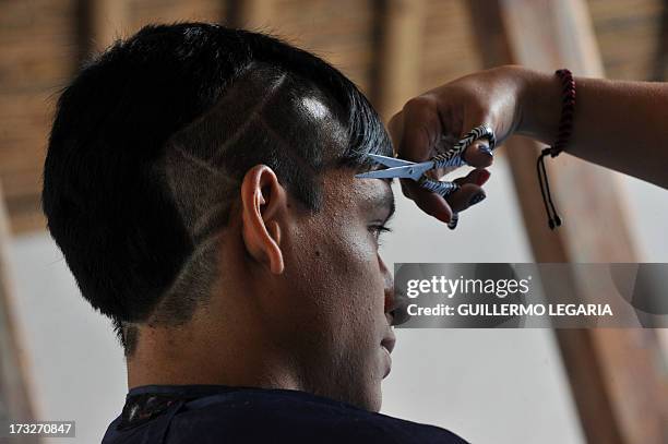 People gather at a workshop at "La Peluqueria" in La Candelaria's neighborhood in downtown Bogota, Colombia on July 10, 2013. AFP PHOTO/Guillermo...